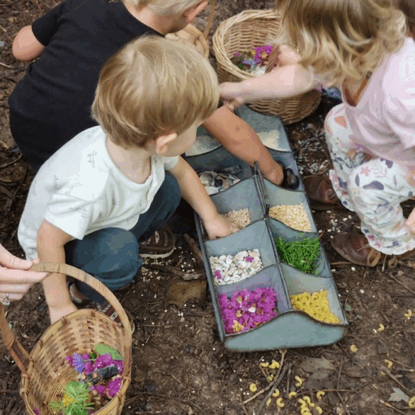 Kids using colorful nature based materials to build mosaics.